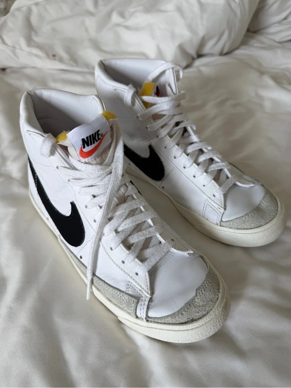 Nike White High-Top Sneakers with Black Swoosh and Orange Accent